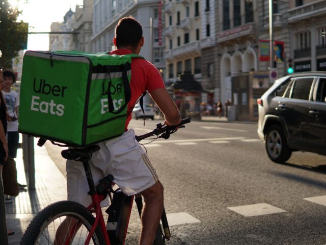 Uber Eats bike delivery driver waiting to cross the road